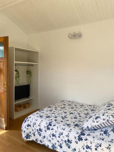a bedroom with a bed with a blue and white comforter at Le Chalet Pignantais in Pignans