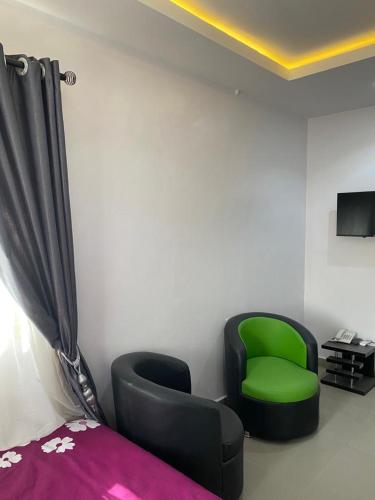 a bedroom with a green chair and a bed at Hope Residence hotel and suite in Lagos