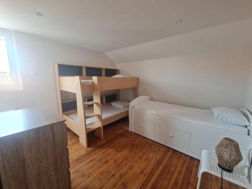 Cette petite chambre comprend un lit et des lits superposés. dans l'établissement Maison La tranche sur Mer proche centre ville et plages, à La Tranche-sur-Mer