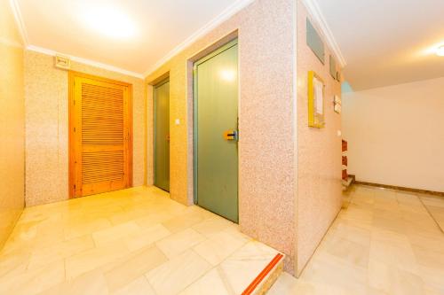 korytarz z zielonymi drzwiami i podłogą wyłożoną kafelkami w obiekcie ALEGRIA ID49 w mieście Torrevieja