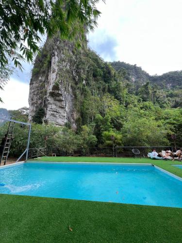 a blue swimming pool in front of a mountain at Mountain View Party Hostel in Ao Nang Beach