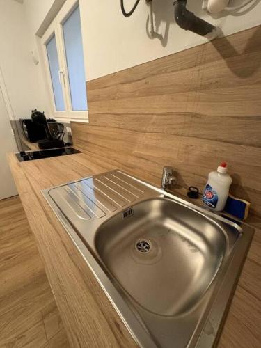 - un évier en acier inoxydable dans une cuisine avec parquet dans l'établissement Jeanne D'arc - RDC Droite, à Rouen
