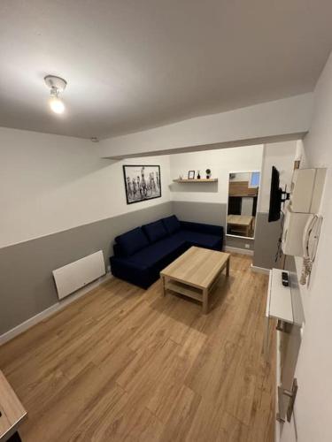 un salon avec un canapé bleu et une table dans l'établissement Jeanne D'arc - RDC Droite, à Rouen