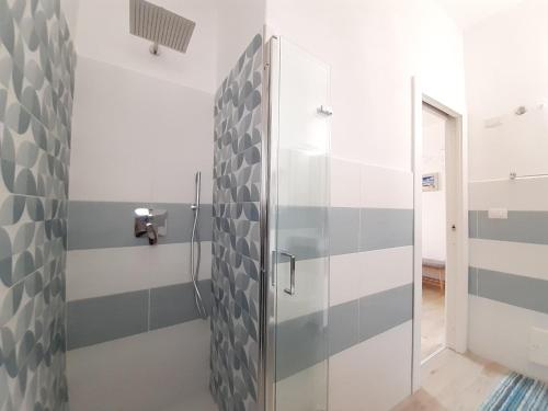 a bathroom with a shower with gray and white stripes at Bellagio in Castelsardo
