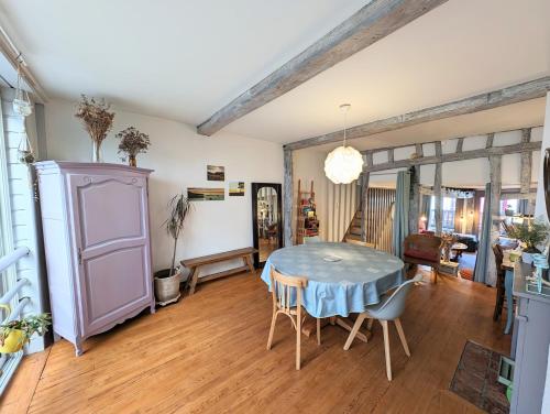 une salle à manger avec une table et des chaises dans l'établissement La bi-coque du Courtgain, charmante et atypique, à Saint-Valery-sur-Somme