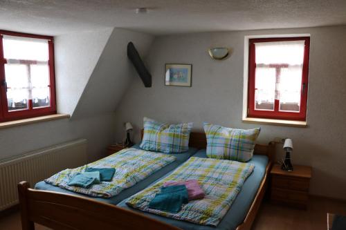 a bedroom with two beds and two windows at Gasthaus Zur Weintraube in Bad Langensalza