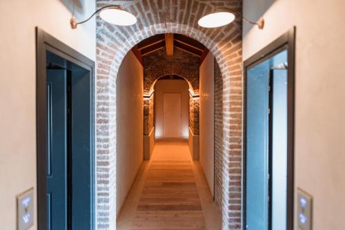 a hallway with a brick wall and two lights at Pavillon Suite in Peschiera del Garda