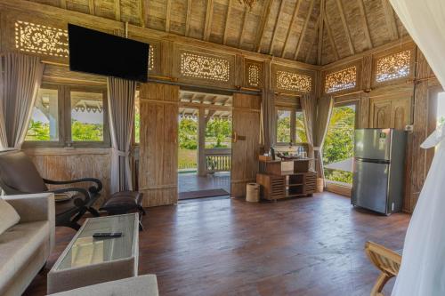 a living room with a couch and a tv in a room at Billys Ayodya Villa in Perean