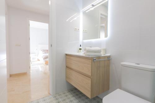 ein Bad mit einem Waschbecken und einem Spiegel in der Unterkunft OceanVibe Loft MalagaFlat in Málaga