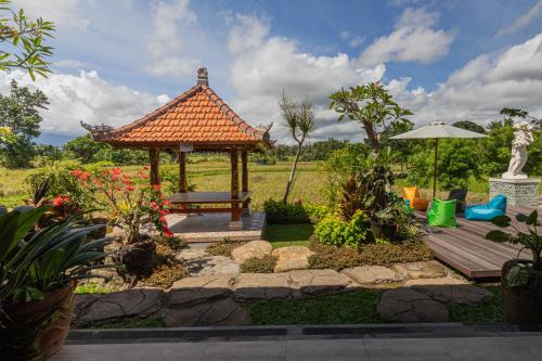 a gazebo with a bench in a garden at Billys Ayodya Villa in Perean
