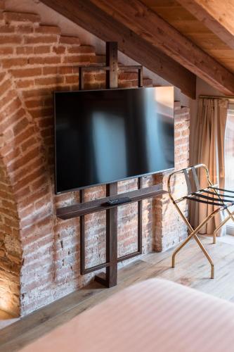 a flat screen tv mounted on a brick wall at Pavillon Suite in Peschiera del Garda