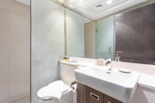 a bathroom with a sink and a toilet and a mirror at Silkhaus Sea View studio in Marina Rise Tower in Abu Dhabi