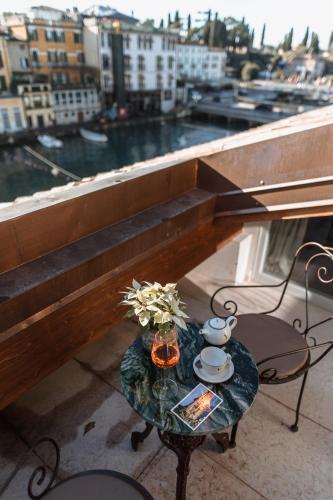 a table on a balcony with a view of a harbor at Pavillon Suite in Peschiera del Garda