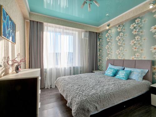 キスロヴォツクにあるТрехкомнатная квартира в тихом месте на ул Крутая дорога 25のベッドルーム1室(青い枕のベッド1台、窓付)