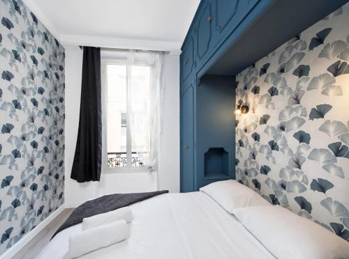 een slaapkamer met een blauwe muur en een wit bed bij Hypercentre - 1mn Monaco - Neuf in Beausoleil