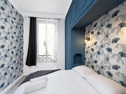 - une chambre avec un mur bleu et un lit blanc dans l'établissement 1mn Monaco - Hypercentre - Appartement rénové - BQ, à Beausoleil
