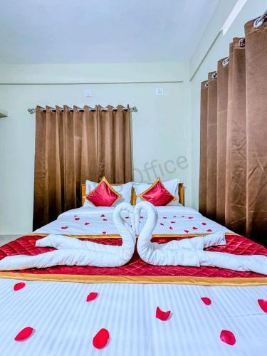 dos cisnes hechos de corazones tirados en una cama en GMR Suites en Kalpatta