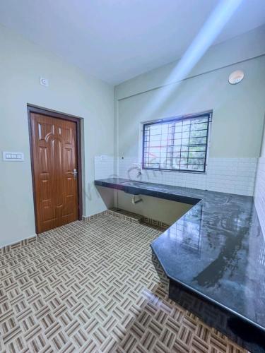 baño con encimera de cristal y ventana en GMR Suites en Kalpatta