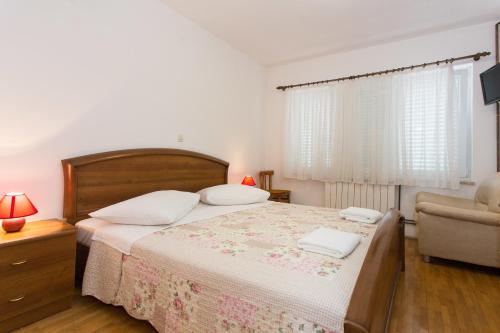 um quarto com uma cama, um sofá e uma cadeira em Bed & Breakfast Mario em Krk