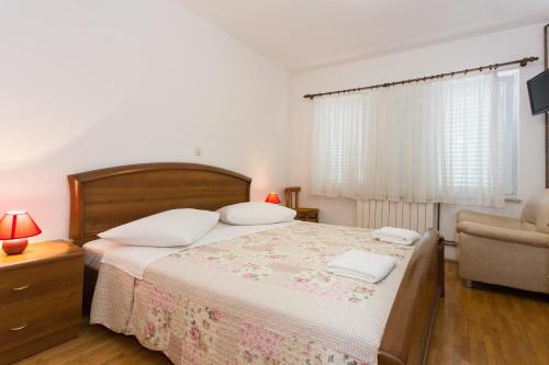 una camera con letto, divano e sedia di Bed & Breakfast Mario a Krk