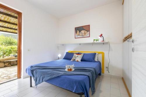 a bedroom with a blue bed and a window at Moon Valley la pelosa in Stintino
