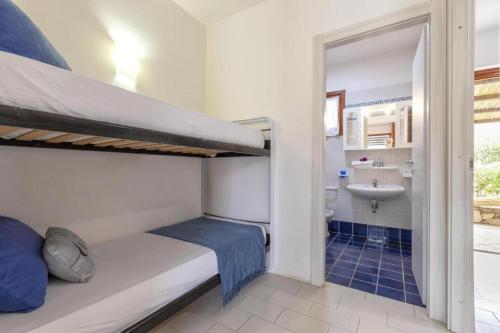 a small room with a bunk bed and a bathroom at Moon Valley la pelosa in Stintino