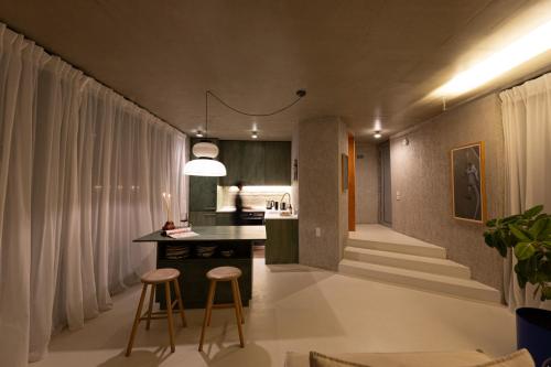 a kitchen and living room with a counter and stools at LASPI / PETRES in Pefkali