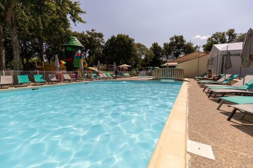 a swimming pool with chairs and a water park at Camping maeva Club Royal Océan in Saint-Sulpice-de-Royan