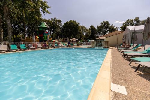 une piscine avec des chaises et un parc aquatique dans l'établissement Camping maeva Club Royal Océan, à Saint-Sulpice-de-Royan