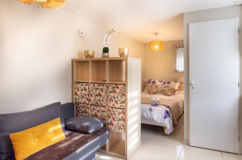 - une petite chambre avec un lit et un canapé dans l'établissement Résidence Lawawi - studio Savoie, à Albertville