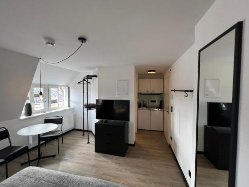 布克斯特胡德的住宿－Studiowohnung 6 in Buxtehude，客厅配有电视、桌子和镜子