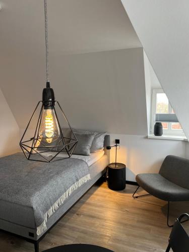 a bedroom with a bed and a chair at Studiowohnung 6 in Buxtehude in Buxtehude