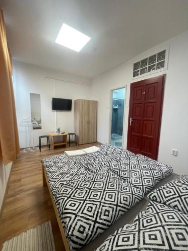 a bedroom with a large bed and a red door at Álom Vendèghàz in Dunaújváros