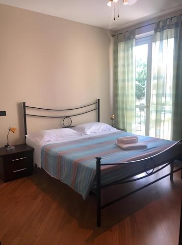 - une chambre avec un lit et une grande fenêtre dans l'établissement Appartamento con parcheggio privato a Lucca, à Lucques