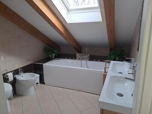 een badkamer met een wit bad, een toilet en een wastafel bij Casa Poli in Turijn