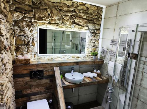 een stenen badkamer met een wastafel en een spiegel bij Liptovský mlyn in Liptovská Teplá