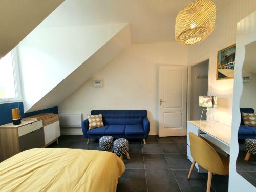a bedroom with a blue bed and a couch at COCOONING TIME in Prenois