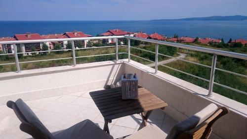 Un balcón con mesa y sillas y el mar. en High in the Sky Apartments, en Sozopol