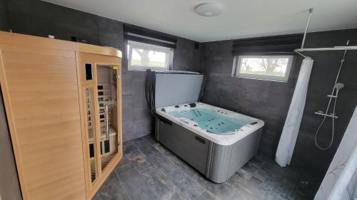 La salle de bains est pourvue d'une baignoire jacuzzi et d'une douche. dans l'établissement Le Gite de la Waldmatt - SPA & Sauna - Proche La Petite- Pierre - Piscine, calme et détente, à Schoenbourg