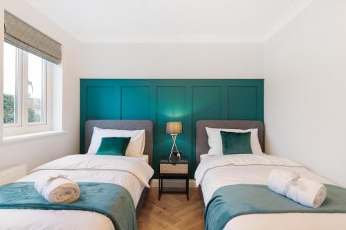 - 2 lits dans une chambre de couleur verte et blanche dans l'établissement Spacious Stunning Flat near Heathrow and Central London, à Hounslow