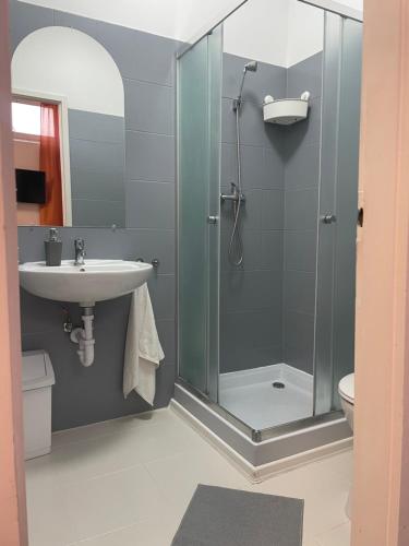 a bathroom with a glass shower and a sink at Álom Vendèghàz in Dunaújváros