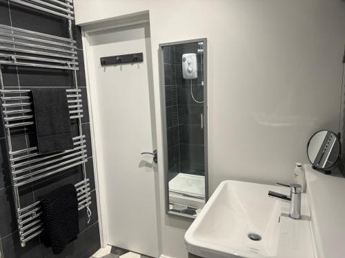 a white bathroom with a sink and a shower at Herne Bay 2-Bedroom House with Private Hot Tub & Garden, Walk to Seafront in Kent