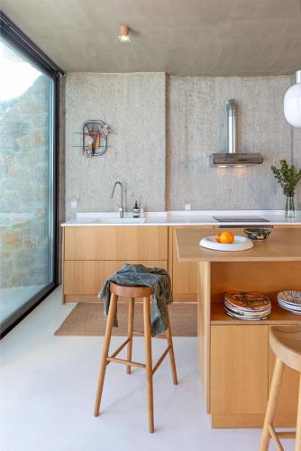 a kitchen with a sink and a table with a stool at LASPI / PETRES in Pefkali