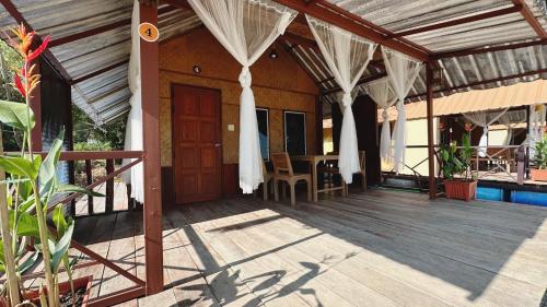 a porch of a house with a wooden deck at อิงน้ำท่าจีน (ท่าจีนรีสอร์ท) in Suphan Buri