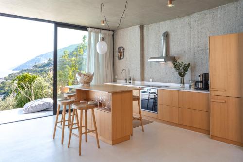 a kitchen with wooden cabinets and a large window at LASPI / PETRES in Pefkali