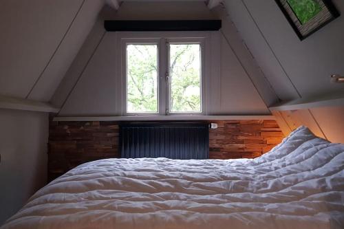 ein Schlafzimmer mit einem großen Bett vor einem Fenster in der Unterkunft Vakantiehuisje familytime - Chalet 122 in Durbuy