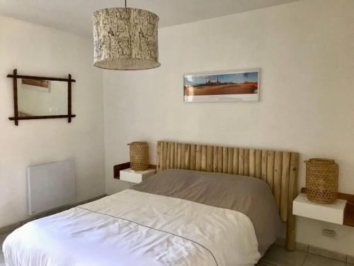 une chambre avec un lit et un lustre dans l'établissement Maison 6 personnes à 100m de la plage Bonne Source, à Pornichet