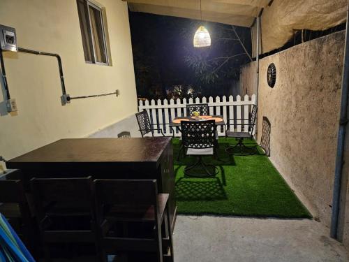 d'une terrasse avec une table, des chaises et une clôture blanche. dans l'établissement La casa de la Gaviota, à Siguatepeque