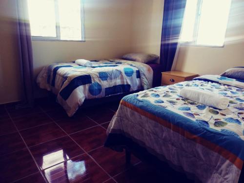 een kamer met 2 bedden en een tegelvloer bij La casa de la Gaviota in Siguatepeque