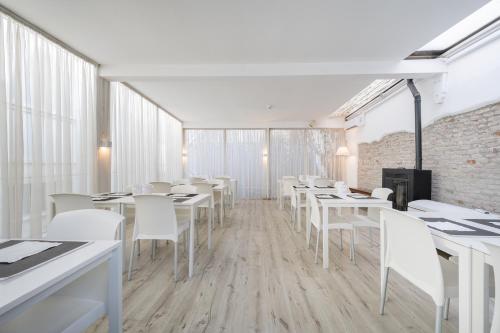 a dining room with white tables and white chairs at Hotel Diana in Ravenna